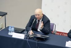 Józef Oleksy siedzi i mówi do mikrofonu