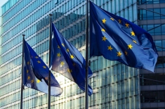 flagi Unii Europejskiej na tle szklanego biurowca