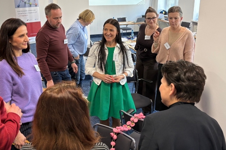 uczestnicy projektu podczas warsztatu - stoją w grupie i rozmawiają