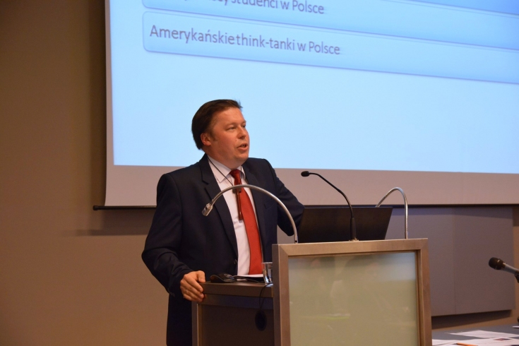 Grzegorz Kozłowski Dyrektor Dep. Ameryki MSZ wygłasza wykład stojąc przy mównicy.