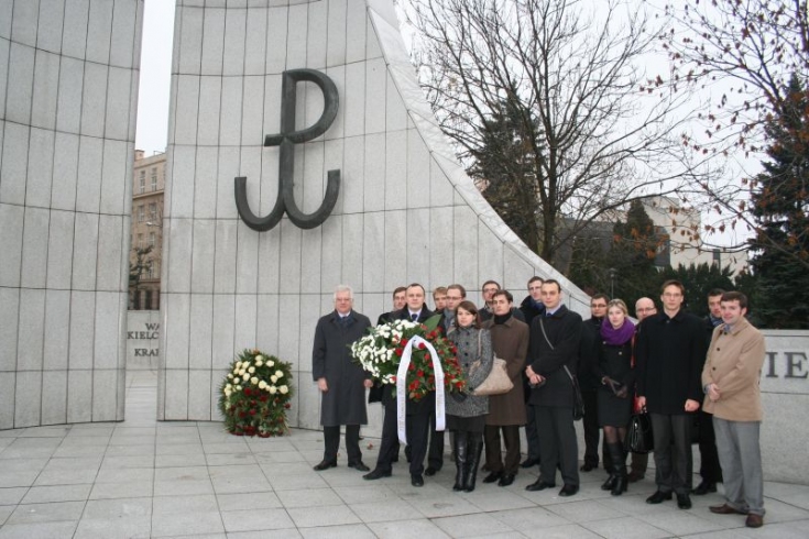 Słuchacze razem z Dyrektorem stoją z pod pomnikiem