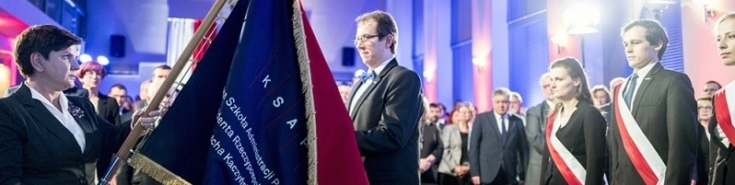 fot. P. Tracz / KPRM Premier Beata Szydło przekazuje nowy sztandar Szkoły Dyrektorowi KSAP. Za Dyrektorem stoi poczet sztandarowy. W tle zebrani goście.